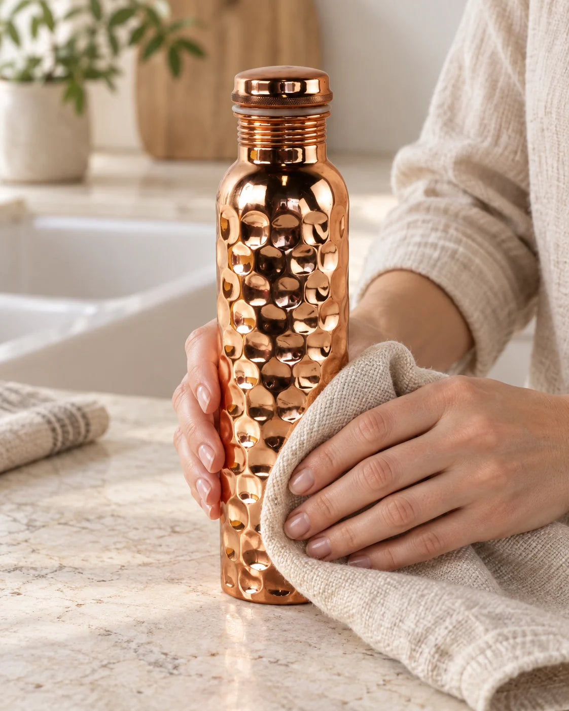 A copper bottle being gently dried with a soft cloth